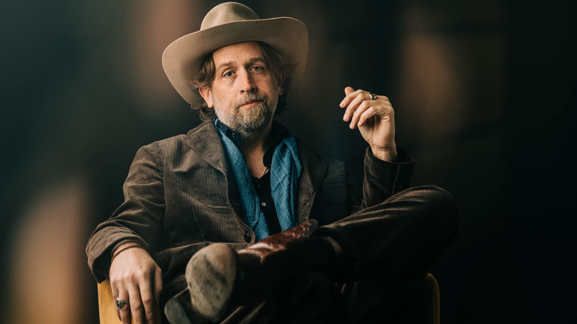 a man with a hat and beard sits for a picture